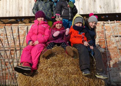 Dzieci siedzące na wsi na beli siana