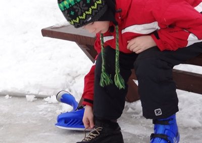 Dziecko przygotowujące się do jazdy na łyżwach po lodowisku na jeziorze